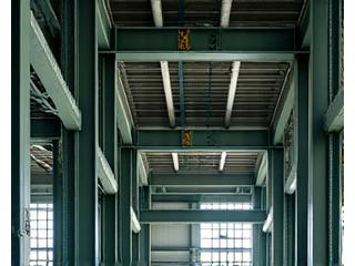 Fireproofing material applied to steel structural beams in an industrial setting, indicating robust safety measures.
